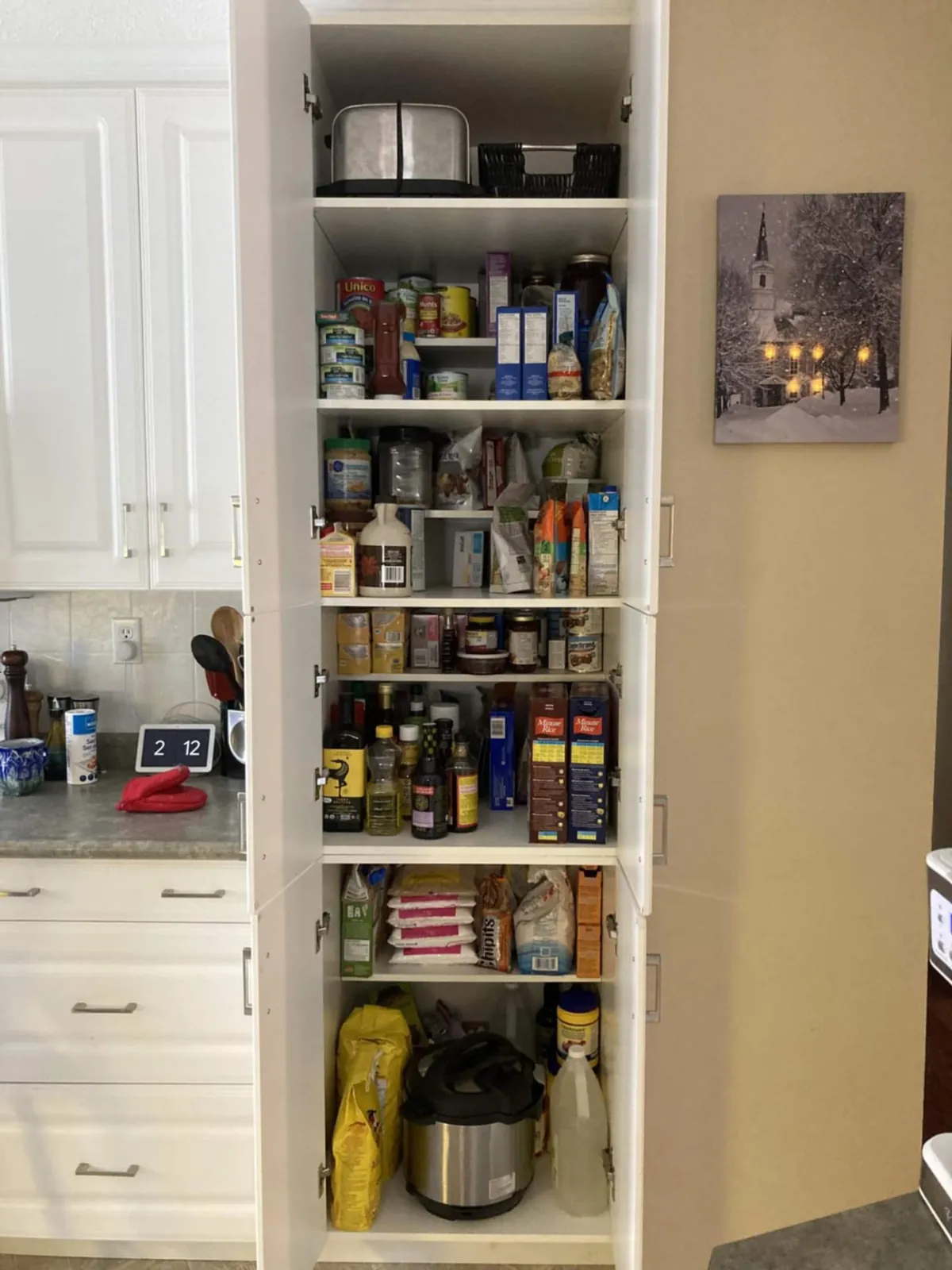 After: the same pantry with cans, jars and boxes grouped on each shelf