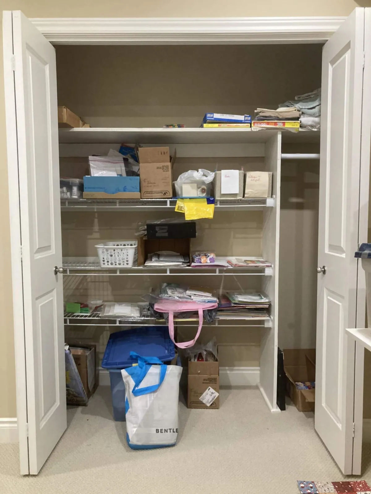 Before: a closet with loose items on wire shelves and bags and boxes on the floor