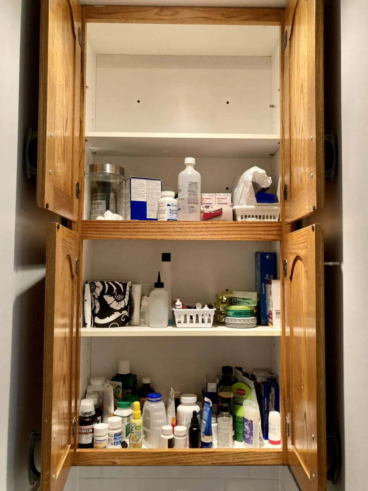 Before: a wooden cupboard crowded with bottles and toiletries