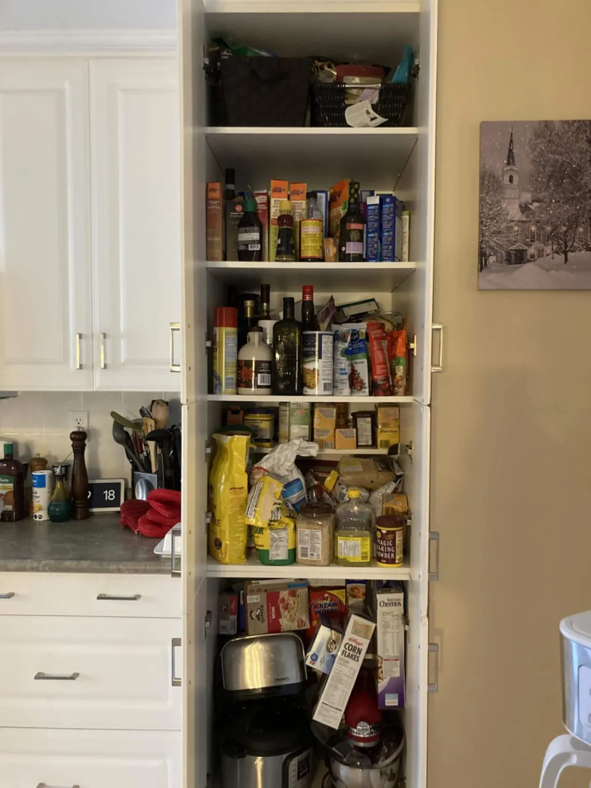 Before: a tall pantry cabinet crowded with food, bottles and small appliances